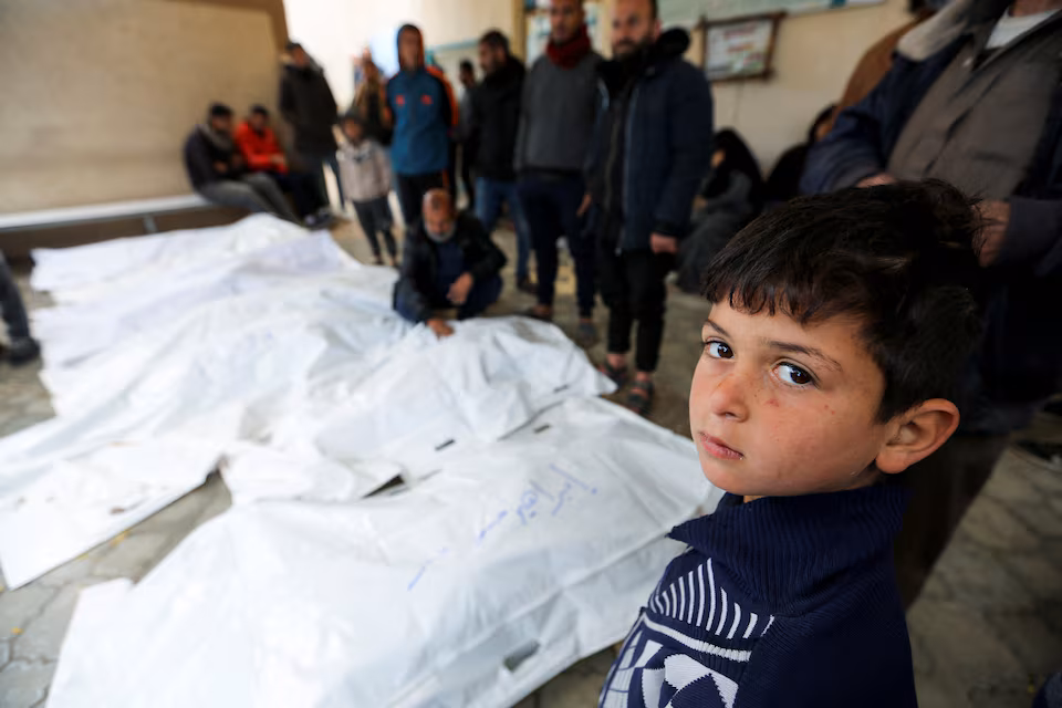 A child looks on as people mourn Palestinians killed in Israeli strikes, at the European hospital in Khan Younis in the southern Gaza Strip March 20, 2025. REUTERS/Hatem Khaled Purchase Licensing Rights